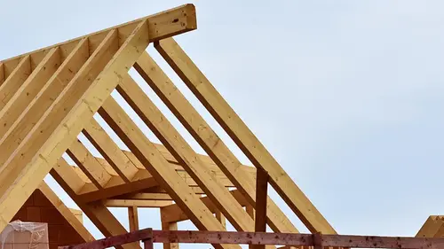 Trästomme med takstolar på ett hus under uppförande.